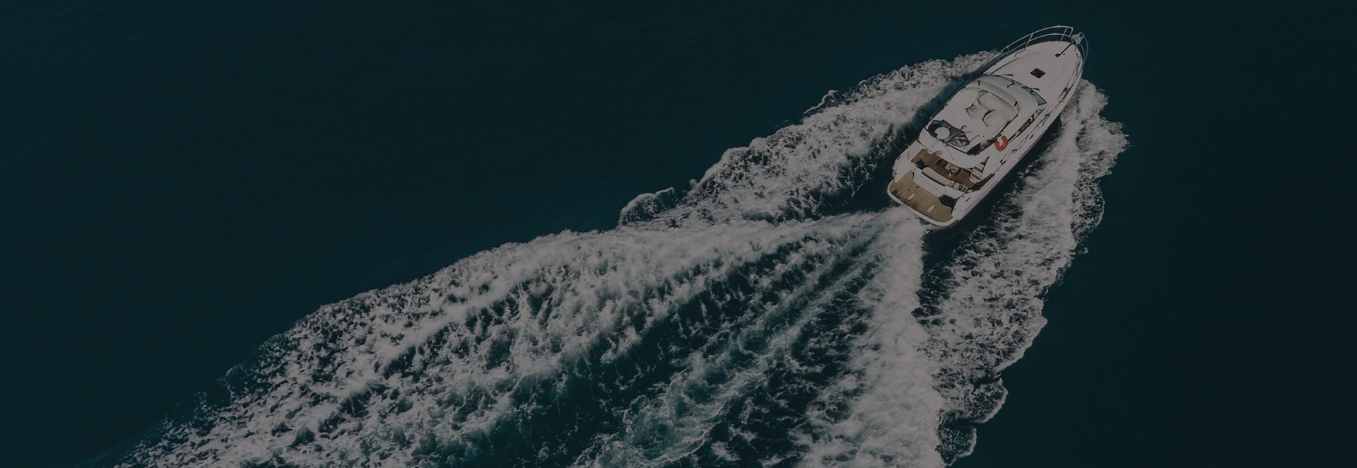 Boat speeding across water leaving a trail of white water behind