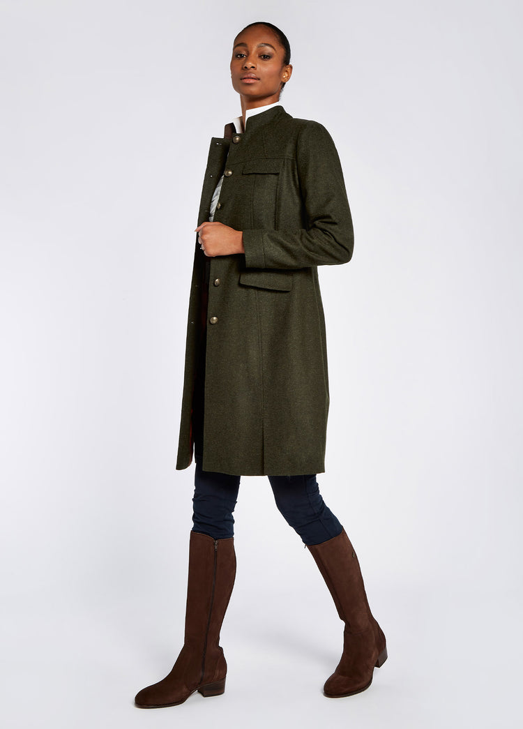 A woman modelling Dubarry women's Coolepark Tweed Loden Coat from the side. She is posing at an angle with the coat unbottoned.