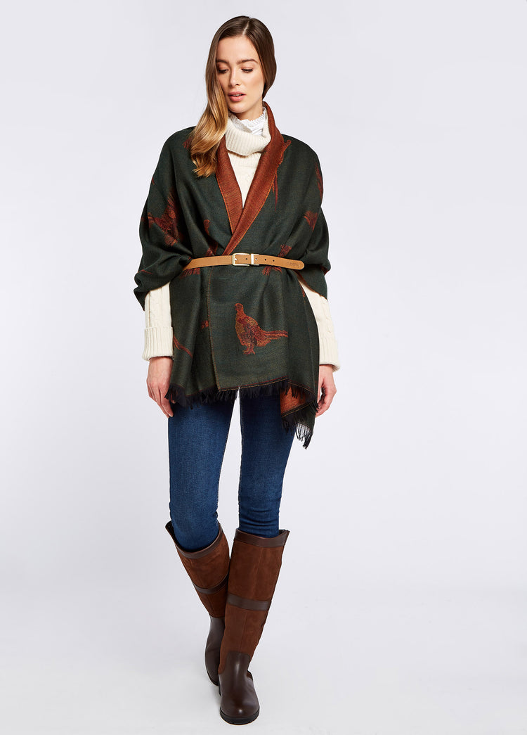 A woman modelling Dubarry women's Birchdale Tweed Ivy Wool draped over her shoulders and tied around her waist with a belt.