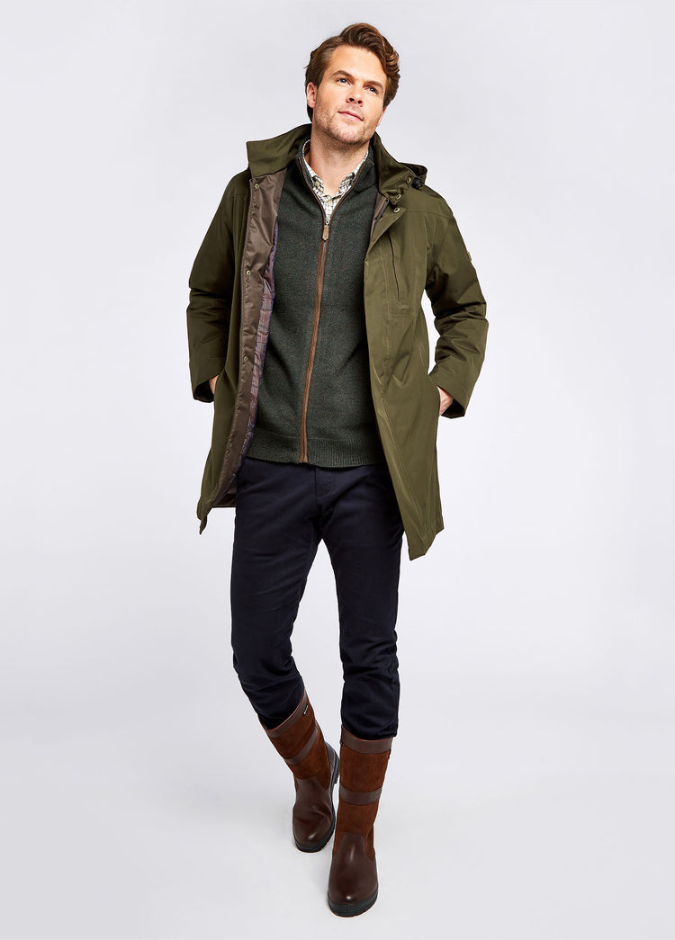 On Model image of a man wearing a Wider calf pair of Dubarry Mens Kildare calf height leather Country Boot, walnut brown colour. He is also wearing a green wax jacket, green zip up fleece, checked shirt, a pair of navy trousers.