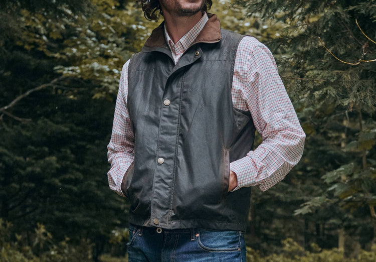 Close up view of the male model's hand in the pocket of a Dubarry Brunswick Mayfly Wax Jacket, olive coloured jacket. The pocket has a leather edge